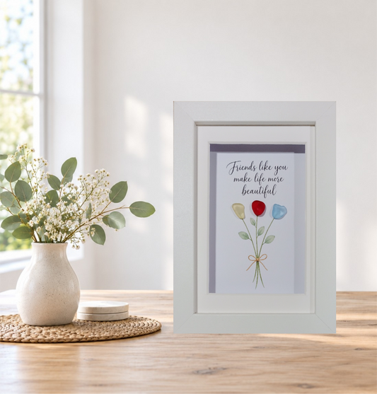 Friends like you make life more beautiful sea glass flower bouquet with bow in a white frame, displayed on a table